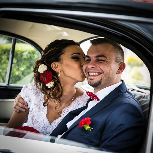 Zdjęcie ślubne, para młoda dojeżdzająca samochodem weselnym do sali weselnej